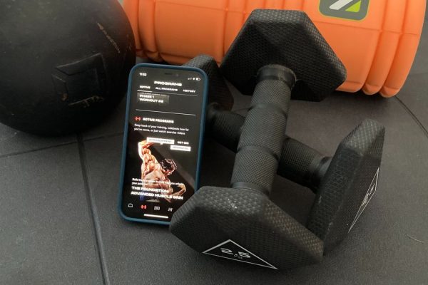 The Pump app on a phone surrounded by fitness equipment