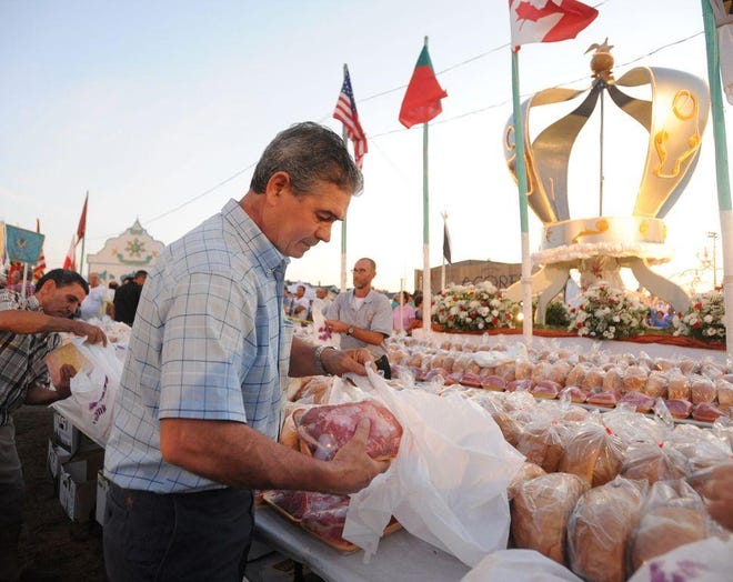 يقوم لويس رودريغيز بتعبئة اللحوم والخبز لتوزيعها على المحتاجين خلال عيد الروح القدس العظيم لعام 2016 في فال ريفر.  تم إلغاء مهرجان 2021، لكن سيستمر المتطوعون في توزيع الطعام على المحتاجين.