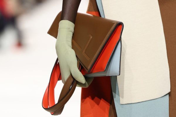 A model carrying a brown and peach bag with green detailing on the Fendi spring 2024 runway