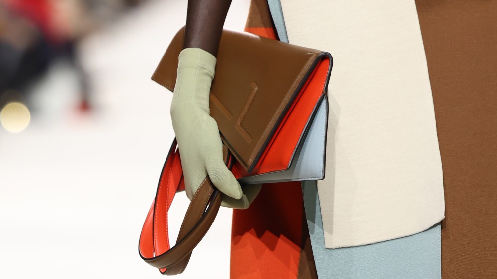 A model carrying a brown and peach bag with green detailing on the Fendi spring 2024 runway