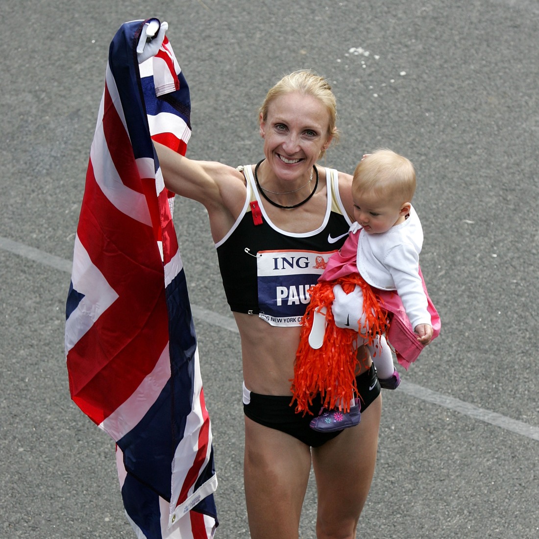 تحتفل باولا رادكليف، وهي تحمل ابنتها إيسلا بذراعها وتحمل العلم البريطاني باليد الأخرى، بعد فوزها بقسم السيدات في ماراثون مدينة نيويورك في 4 نوفمبر 2007.