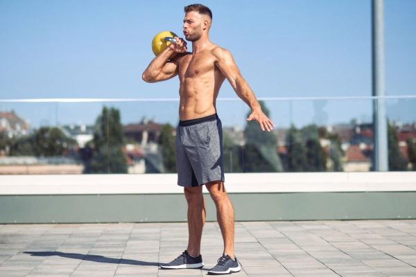 a man performing a kettlebell workout outside